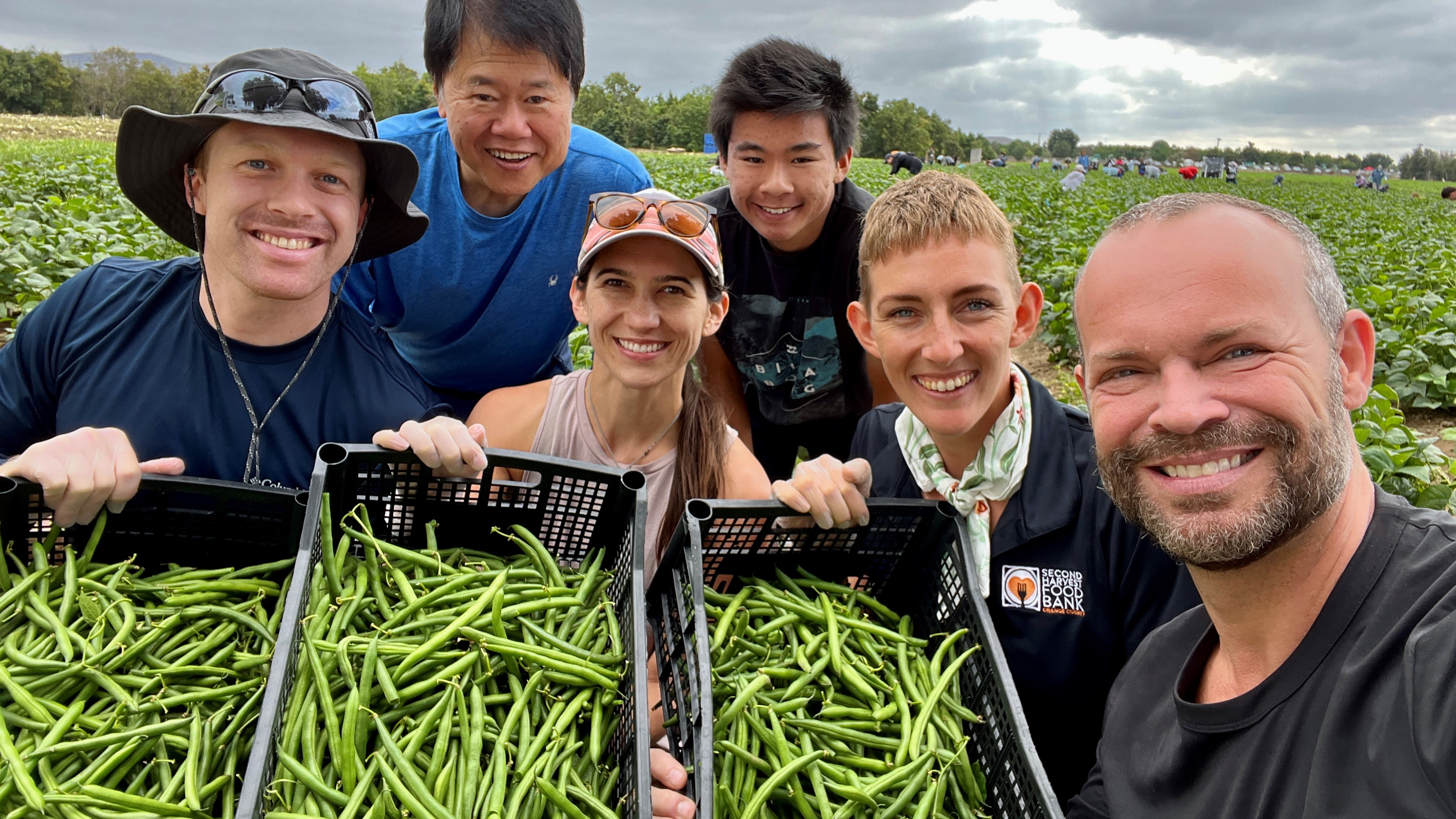 Volunteers for Second Harvest Food Bank and America’s Heartland host Rob Stewart at a green bean field in Orange County, CA